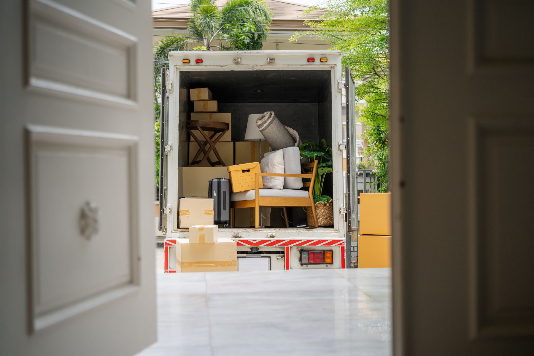 Moving truck filled with boxes, furniture, and household items parked in a residential driveway